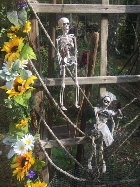 Skull Figures and Sunflowers at the Garden Gate