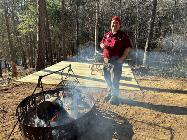 Karl, the trail and deck builder, relaxes near the deck and fire pit.